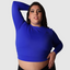 Shop our sportswear in plus sizes. Made with long sleeves and breathable sweat wicking fabric. Pair with our yoga pants for gym workout. Shop the best activewear online. Plus size model lifting weights in blue long sleeves gym shirt.